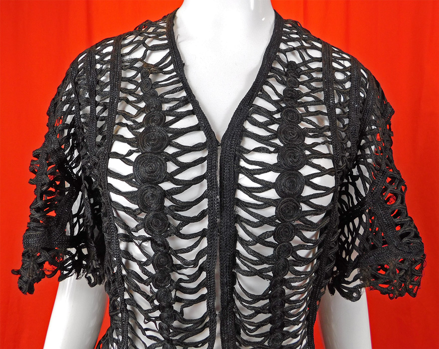 Victorian Black Silk Battenburg Braided Woven Tape Lace Latticework Jacket
It is made of a sheer black silk Battenburg braided woven tape lace latticework with decorative criss crossing, spiral circular pattern designs.