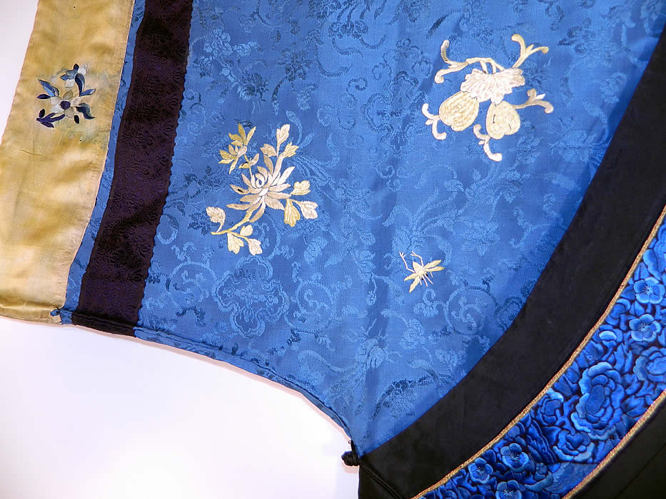 Antique Chinese Blue Silk Embroidered Insect Gourd Peach Floral Longevity Robe. This magnificent Manchu style robe is loose fitting, a long mid length, with a rounded neckline, wide full sleeves and a side opening with black silk loop toggle closures. 