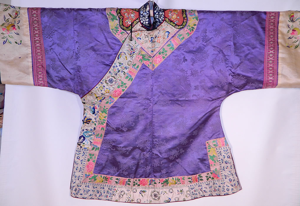 Antique Chinese Purple Silk Damask Floral Brocade Figural Embroidered Trim Robe
This magnificent Manchu womens robe has a blue silk embroidered mandarin collar, cinnabar color embroidered shoulder epaulettes, black silk knotted loop toggles for closure along the side, long full sleeves with wide cuffs, side skirt vents and has been fully relined in a blue silk fabric. 