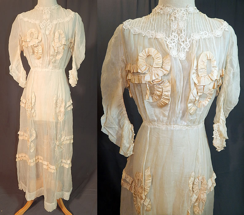 Edwardian White Cotton Muslin Lace Silk Ribbon Ruched Ruffle Trim Wedding Dress
This antique Edwardian era white cotton muslin lace silk ribbon ruched ruffle trim wedding dress dates from 1910. It is made of a sheer fine off white cotton muslin fabric, with lace trim around the neckline, yoke, cuffs and cream silk ribbon ruched ruffle bow trim accents appliquéd
