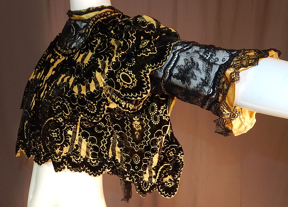 Victorian Yellow Silk Black Burnout Voided Velvet Devore Chantilly Lace Bodice
This beautiful bodice has a short cropped top blouse style, with a sheer black Chantilly lace lining underneath, short lace sleeves with gold metallic thread stitching, ruffle cuffs, a high lace trimmed neckline and a scalloped edging open back with no closure. 