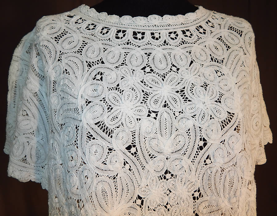 Vintage White Battenburg Tape Lace Sheer Shirt Blouse
This vintage white Battenburg tape lace sheer shirt blouse dates from the 1940s. It is made of a sheer white filmy linen tape lace, with veined, raised threads flowers, leaves, scrolling designs joined by bobbin made braids and thread bars.
