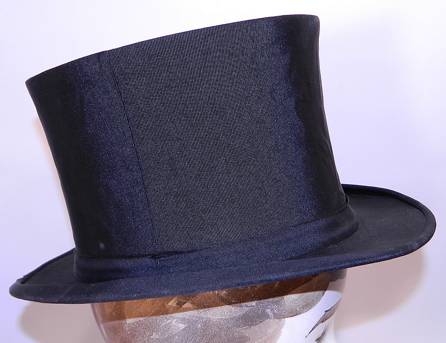 Vintage Kennedys Victorian Gentlemen Black Silk Collapsible Opera Top Hat. It is made of a black silk grosgrain ribbed textured fabric, with matching hat band trim. 