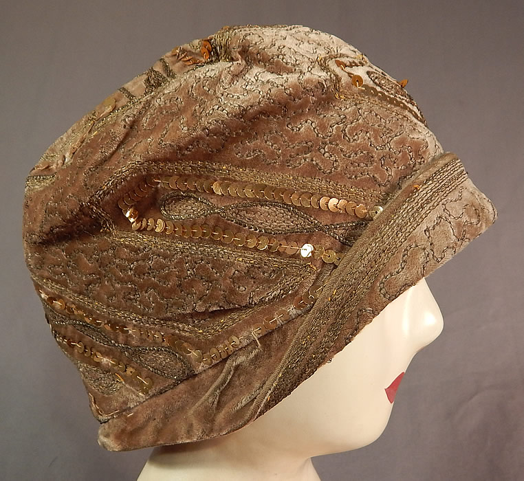 Vintage Art Deco Gold Lamé Embroidery Sequin Beaded Flapper Cloche Hat
The hat is made of a beige taupe color velvet fabric, with gold metallic lamé chain stitching embroidery work and gold metallic sequin beading all done in decorative geometric zigzag designs. 

