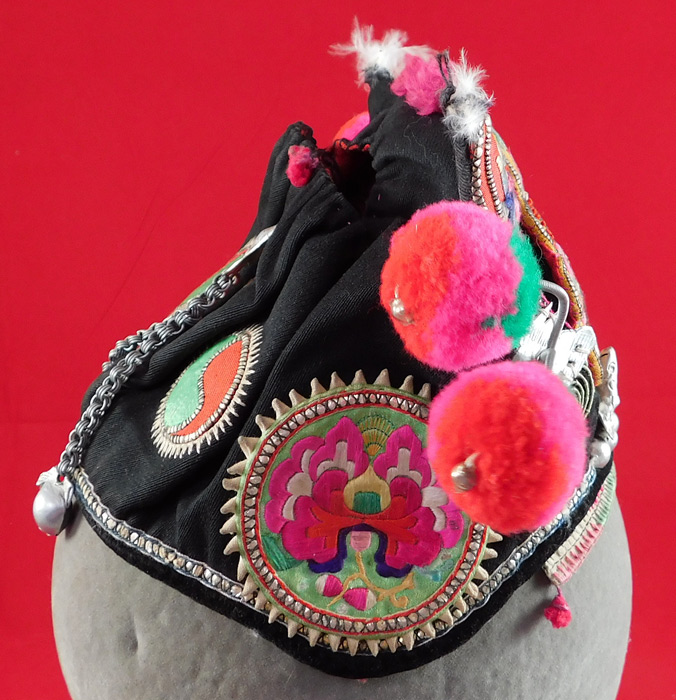 Antique Chinese Bai Miao Minority Childrens Festival Embroidered Tiger Wind Hat
The tigers ferocious powers make it an especially popular protective image and would have been used to frighten off evil spirits. This charming child's wind hat has yin and yang symbols, peony flowers, pheasant bird embroidered roundels medallion appliques on the sides and back with silver bells hanging down on chains, an open top crown and is fully lined with a colorful floral print cotton fabric inside. It is in excellent condition. 