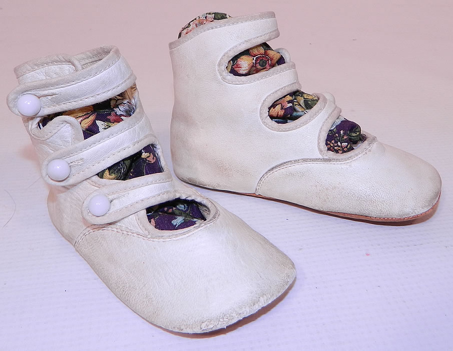 Victorian White Kid Leather High Button Strap Baby Boots Infant Childrens ShoesThis pair of Victorian era antique white kid leather high button strap baby boots infant childrens shoes date from 1900. They are made of a white kid leather, with three straps and white porcelain buttons for closure. 