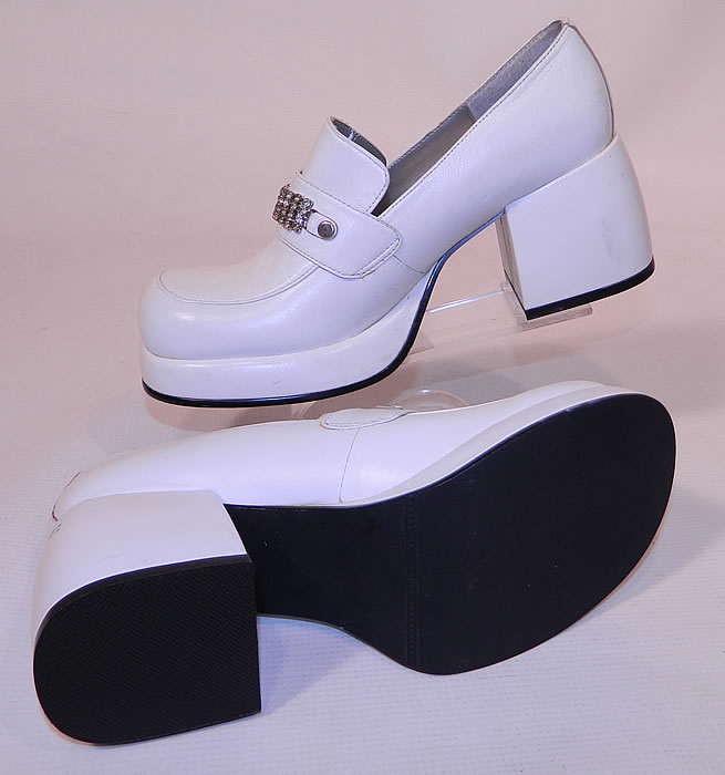 Unworn Vintage Baci Rhinestone Trim White Leather Loafers Disco Platform Shoes. The shoes measure 10 inches long, 4 inches wide, with 2 1/2 inch high heels. They are in excellent unworn condition and have never been worn, with only some minor scuff marks from storage. These are truly a wonderful piece of wearable shoe art!