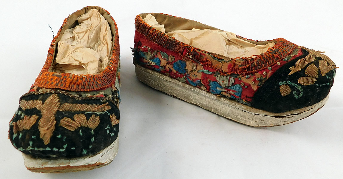 Antique 19th Century Chinese Silk Embroidered Childs Wedge Pedestal Boat Shape Shoes
The shoes measure 6 1/2 inches long, 2 inches wide, with a 3/4 inch high wedge heel. 