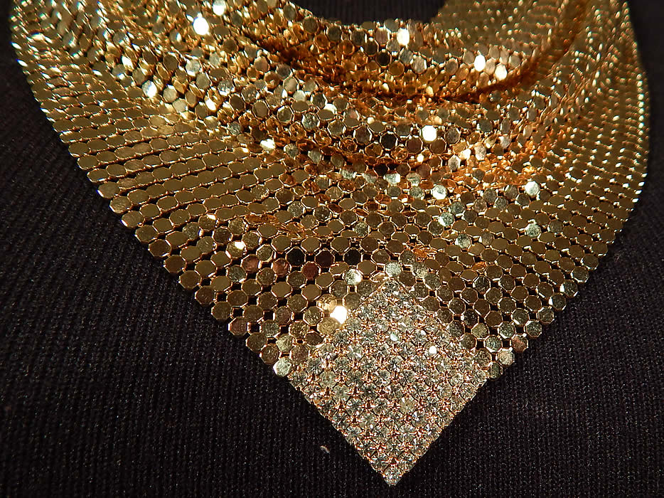 Vintage Whiting & Davis Gold Metal Mesh Rhinestone Bib Necklace Scarf Collar
This beautiful bib necklace has a scarf collar style with a draping cowl front neckline and adjustable chain link strap hook clasp closure on the back neck. There is no label, but was created using Whiting and Davis metal mesh.