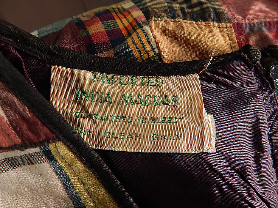 Vintage Peck & Peck Fifth Ave NY Imported India Madras Patchwork Shift Dress
This womens colorful loose fitting straight shift style dress is sleeveless, with blue trim edging the rounded neckline, armholes, is fully lined and has a zipper back closure. 