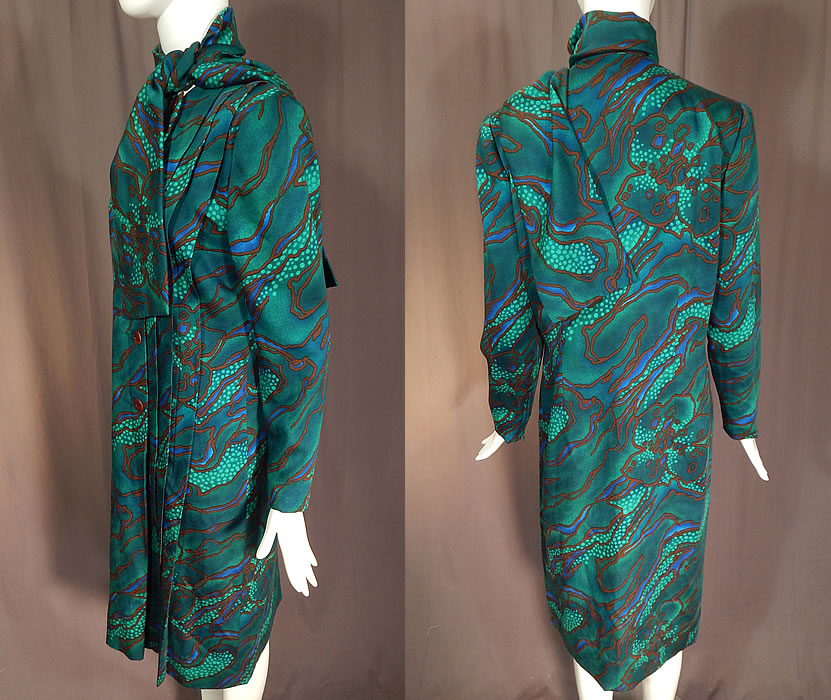Vintage Pauline Trigere Green Abstract Stained Glass Floral Print Neck Scarf Dress
This delightful designer dress has an attached neck scarf, shoulder padding, long tapered sleeves with zipper closure cuffs, pleating along the side opening, with button closures and is fully lined.