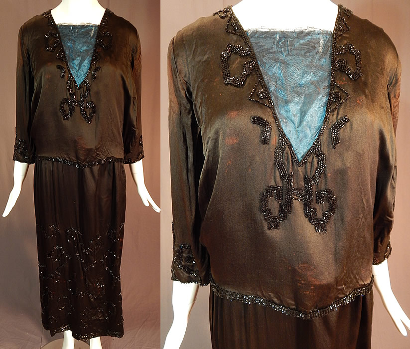 Vintage Art Deco Black Silk Pyramid Beaded Watteau Back Drape Flapper Dress
This fabulous flapper dress has a Grecian style, with layered tunic design, watteau back drape panel attached at the shoulders and bottom skirt hem, backed in a blue silk fabric, black Chantilly lace trim insert on the front top, layered sleeves attached underneath to a silk camisole lining inside, a beaded rope tassel ends sash belt, snaps closures along the side and shoulder. The dress measures 51 inches long, with a 38 inch bust, 30 inch waist, 42 inch hips, 14 inch back and 19 inch long sleeves.