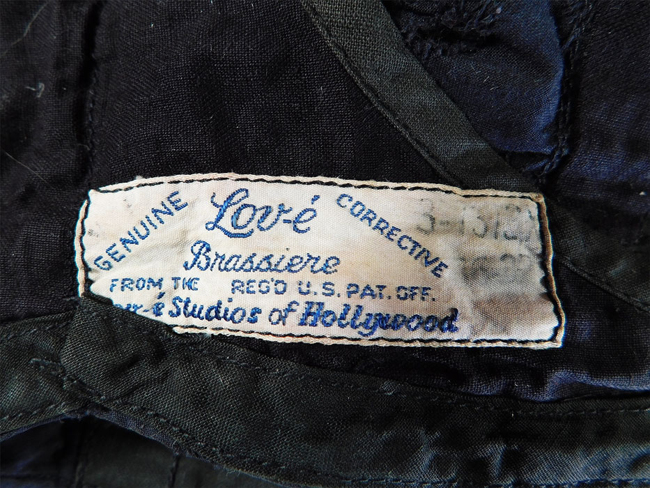 Vintage Lov-e Studios of Hollywood Brassiere Black & Blue Eyelet Corrective Bra
There is a "From The Lov-e Studios of Hollywood Genuine Corrective Brassiere" label, size 32-36 tag sewn inside.