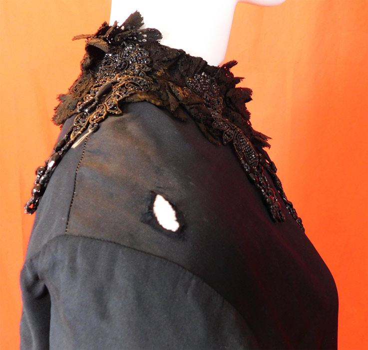 Victorian Black Silk Jet Beaded Fringe Tassel Trim Dolman Mantle Cloak Cape
It is in fair as-is condition, needing some restoration, with several small frays, splits scattered on the silk fabric, a small frayed hole on the shoulder, some discoloration fading on the black lace collar trim and some loose, missing beads (see close-ups). This is truly a wonderful piece of antique Victoriana wearable art! 