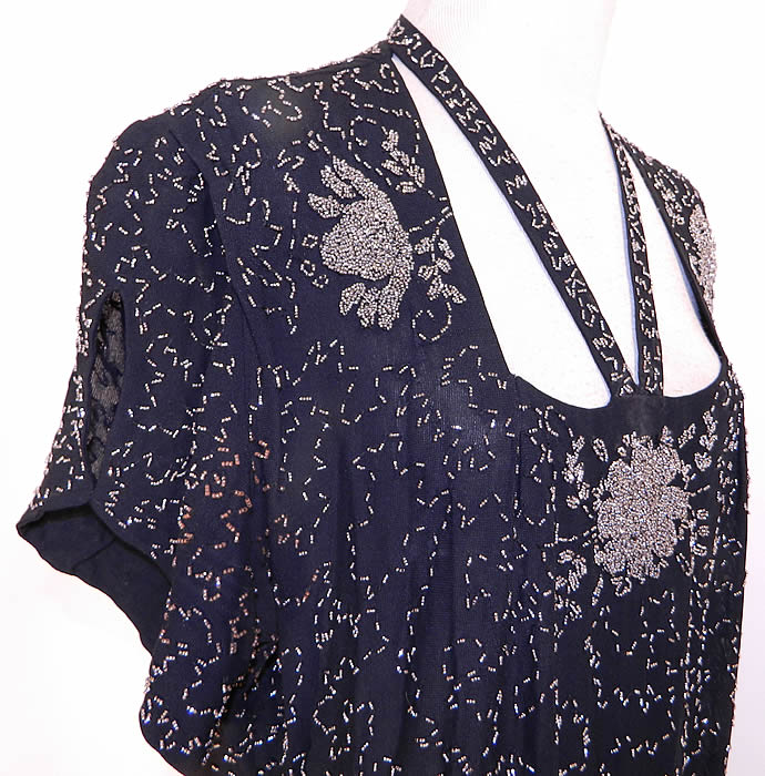 Vintage Black Silk Crepe Steel Cut Beaded Belted Peplum Dress. It is in good wearable condition, with a tiny hole on the skirt and only a small amount of rust discoloration on the beads under one arm.