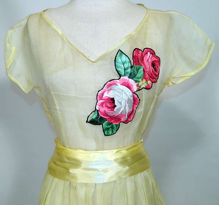 Vintage Yellow Organdy Pink Roses Chintz Applique Belted Dress. This gorgeous garden party dress is a long floor length with a full skirt, pleating, V front neckline, short cap sleeves, side zipper closure and yellow satin ribbon belted sash with back bow. 