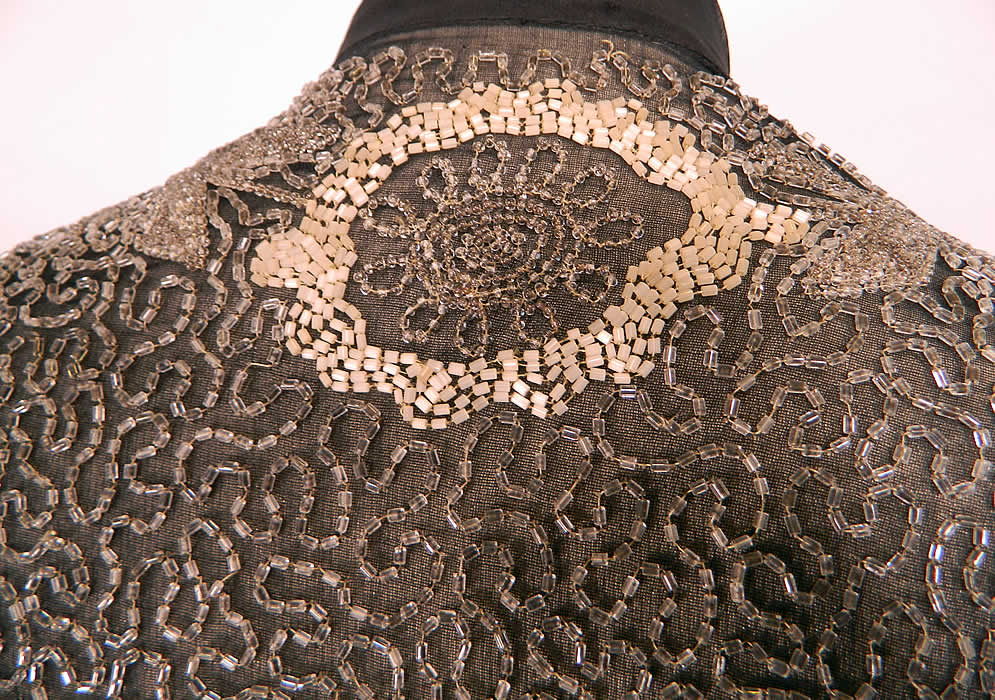 Vintage Art Deco Black Silk Chiffon White Beaded Flapper Evening Coat Jacket. It has wonderful workmanship and details. The jacket measures 33 inches long in the front, 26 inches long in the back, with a 42 inch waist, 36 inch bust, 16 inch back and 23 inch long sleeves. 