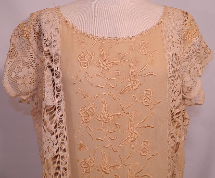 Vintage Cream Silk Butterfly French Knot Embroidered Filet Lace Drop Waist Dress. It is made of an off white cream color fine silk fabric, with raised padded satin stitch and French knot embroidery work done in a floral butterfly design and filet lace inserts done in a floral rose vine leaf pattern.