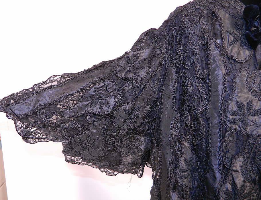 Victorian Fuchs & Rosenberger Berlin Black Silk French Knot Battenburg Tape Lace  Coat. This lovely lace loose fitting coat jacket has a flared swing style, with gathered black silk chiffon ruffle trim edging down the front opening, a black velvet ribbon bow tie trimmed neck collar, full flared wide bell shape sleeves, hook closures on front and is fully lined in black silk. 