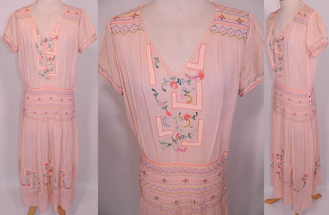Vintage Peach Cotton Drop Waist Floral Embroidered Smocking Boho Peasant Dress. This vintage peach cotton drop waist floral embroidered smocking boho peasant dress dates from the 1920s. It is made of a pale pastel peach color cotton batiste fabric, with colorful pastel floral raised padded satin stitch, french knot hand embroidery work, drawn cut work, ruched smocking and rosettes.