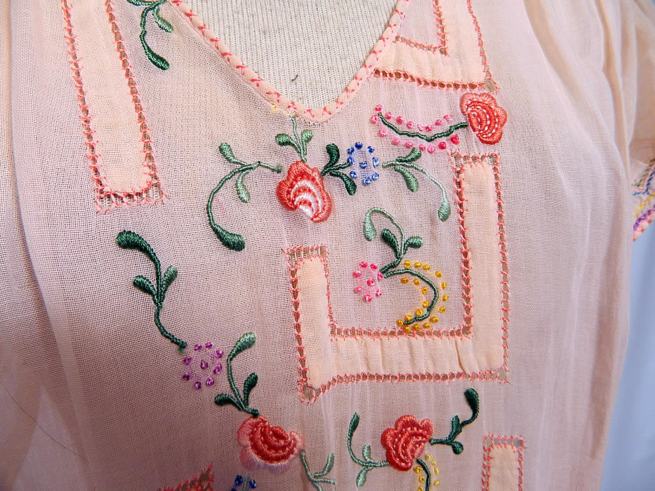 Vintage Peach Cotton Drop Waist Floral Embroidered Smocking Boho Peasant Dress. This pretty peasant style bohemian Hungarian Czech folk dress has a drop waist, V front neckline, short sleeves, smocked shoulders, waistband and side snap closures. The dress measures 49 inches long, with 38 inch hips, a 30 inch waist and 36 inch bust.