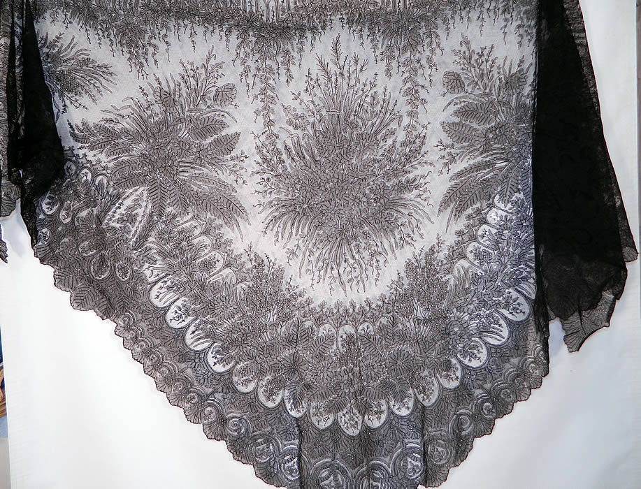 Victorian Civil War Antique Black Chantilly Lace Mantilla Shawl. It is made of a sheer fine black net French chantilly lace, with a floral foliage leaf pattern outlined in black threads with detailed shading effects and a beautiful decorative scalloped border edging.
