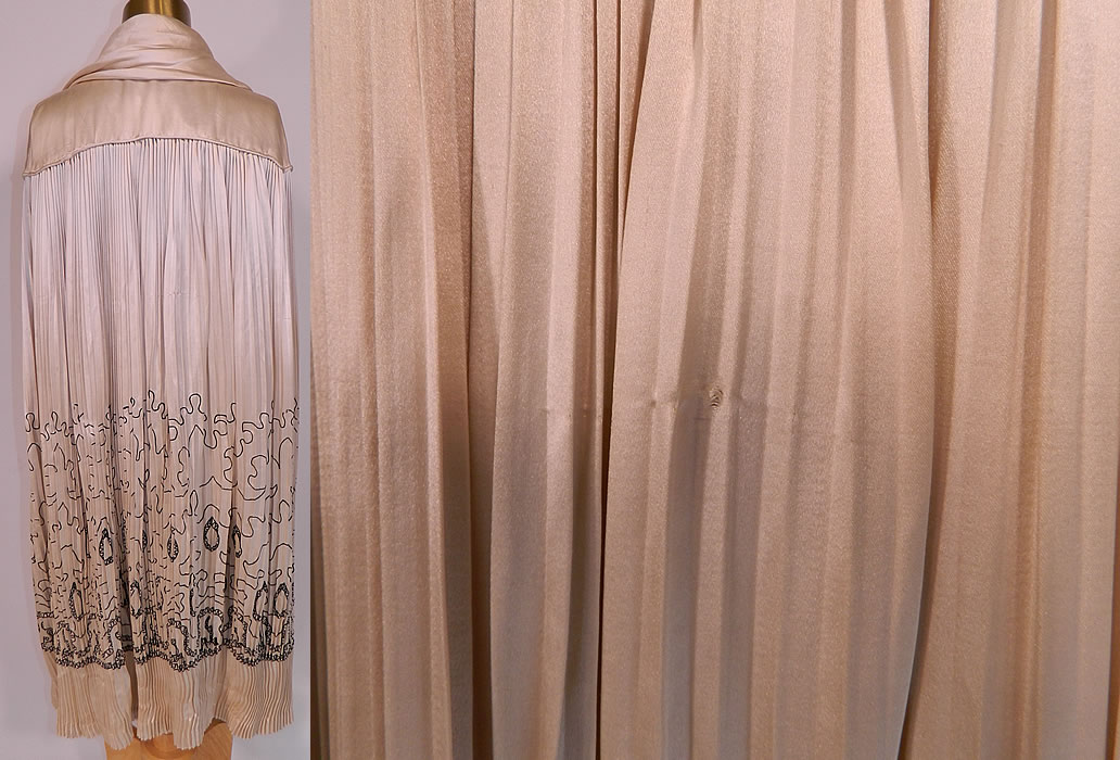 Vintage Art Deco Cream Silk Pleated Black Embroidered Evening Flapper Cloak Cape. The cape measures 45 inches long, 20 inches across the shoulders and is 75 inches in circumference. This amazing antique Art Deco cream silk pleated black embroidered evening flapper cloak cape dates from the 1920s. This is truly a wonderful piece of wearable Art Deco textile art! It is in good condition, with only some fraying of the inside silk lining on the back neck and a tiny snag pull on the back (see close-up). 