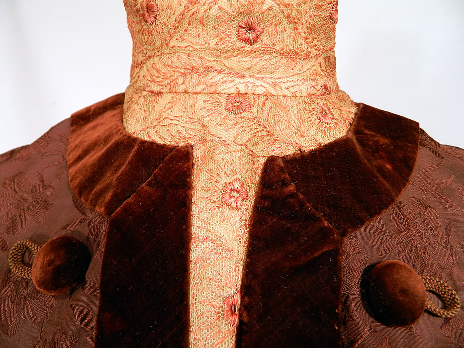 Edwardian Brown Silk Damask Floral Brocade Embroidered Lace High Collar Dress Gown. It is made of a dark chocolate brown color silk damask floral pattern brocade fabric, with brown velvet button trim edging and an off white cream color net lace pink embroidered yoke high neck collar insert and cuffs.