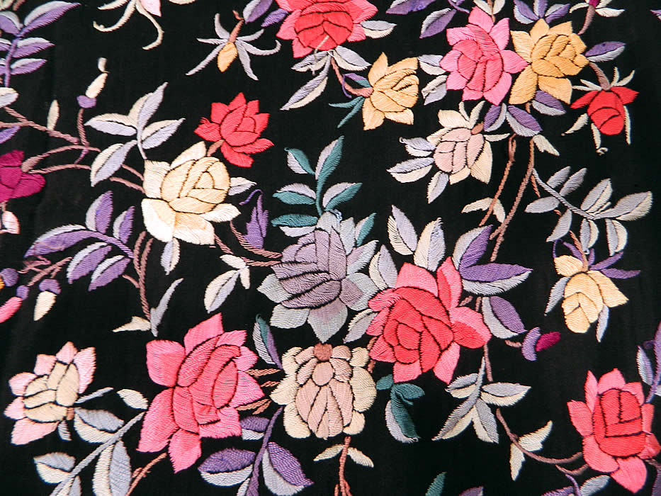 Antique Black Silk Floral Roses Pastel Embroidered  Canton Piano Shawl. There is a lush floral foliage vine leaf pattern with a variety of rose flowers embroidered throughout. There is a fabulous hand knotted macram&eacute; black silk fringe which measures 18 inches long surrounding the entire shawl with rounded corners.