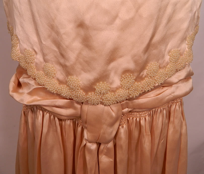 Vintage Cream Silk Pearl Beaded Handkerchief Scalloped Skirt Drop Waist Wedding Dress. This beautiful bridal wedding gown dress is loose fitting, has a drop waist, with attached sleeveless overblouse top, a belted sash waist with pleated gathering, an uneven handkerchief scalloped hem full skirt and lined top.
