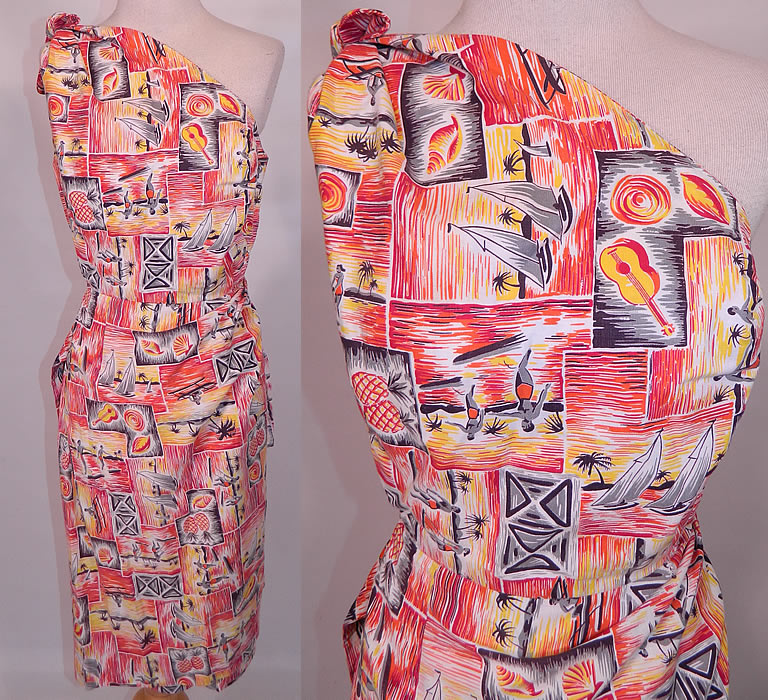 Vintage Hawaiian Surfer Pineapple Print Cotton Off One Shoulder Sarong Dress. This vintage Hawaiian surfer pineapple print cotton off one shoulder sarong dress dates from the 1950s. It is made of a cotton fabric with bright golden yellow, orange, red colors and a black & white Hawaiian tropical print with surfers, sail boats, outrigger canoes, pineapples and seashells.