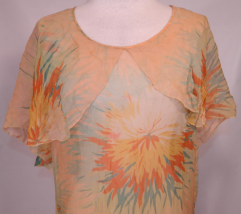 Vintage Yellow Marigold Flower Print Silk Chiffon Lace Skirt Drop Waist Dress. This fabulous floral flapper dress is loose fitting, with a drop waist, a large shawl capelet collar sleeveless top, matching fabric flower trim sewn on the side hip, a short skirt with sheer lace trim and is unlined.