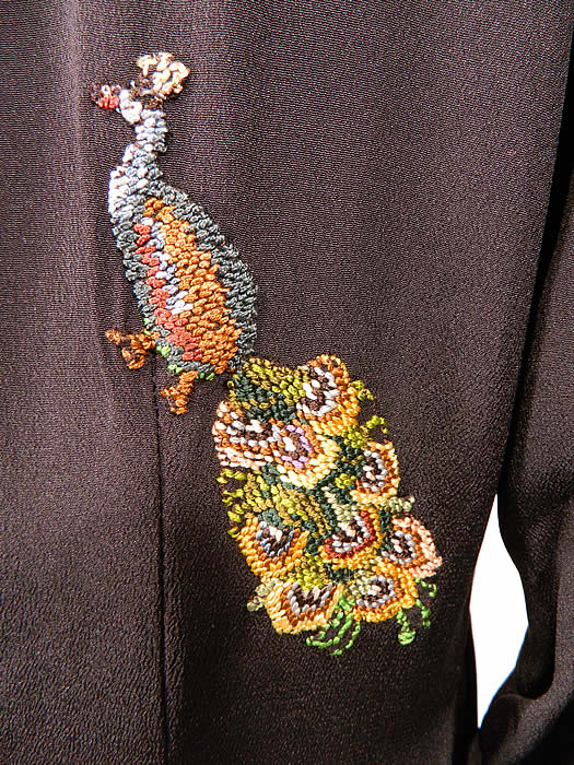 Vintage Black Silk Crepe Peacock Embroidered Needlepoint Maxi Dress Gown. This stunning maxi dress evening gown has a straight loose fitting, long floor length style, with pleated shoulders, long tapered fitted sleeves, lined top, a key hole opening back with button closure at the neck and side snap closures. 