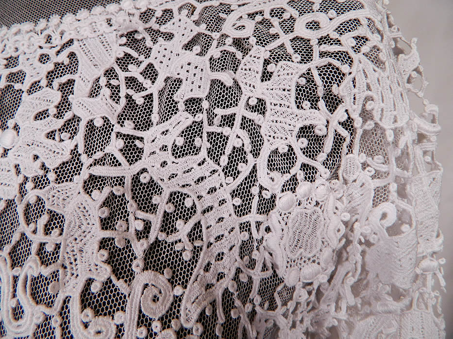 Edwardian White Needle Point Lace Figural Animal Insect Bird Blouse.
This beautiful blouse has a sheer net neckline yoke with a scalloped trim high neck collar, long sleeves, a fitted waist, hook closures down the back and is fully lined in a white net mesh fabric with exposed bottom sides.