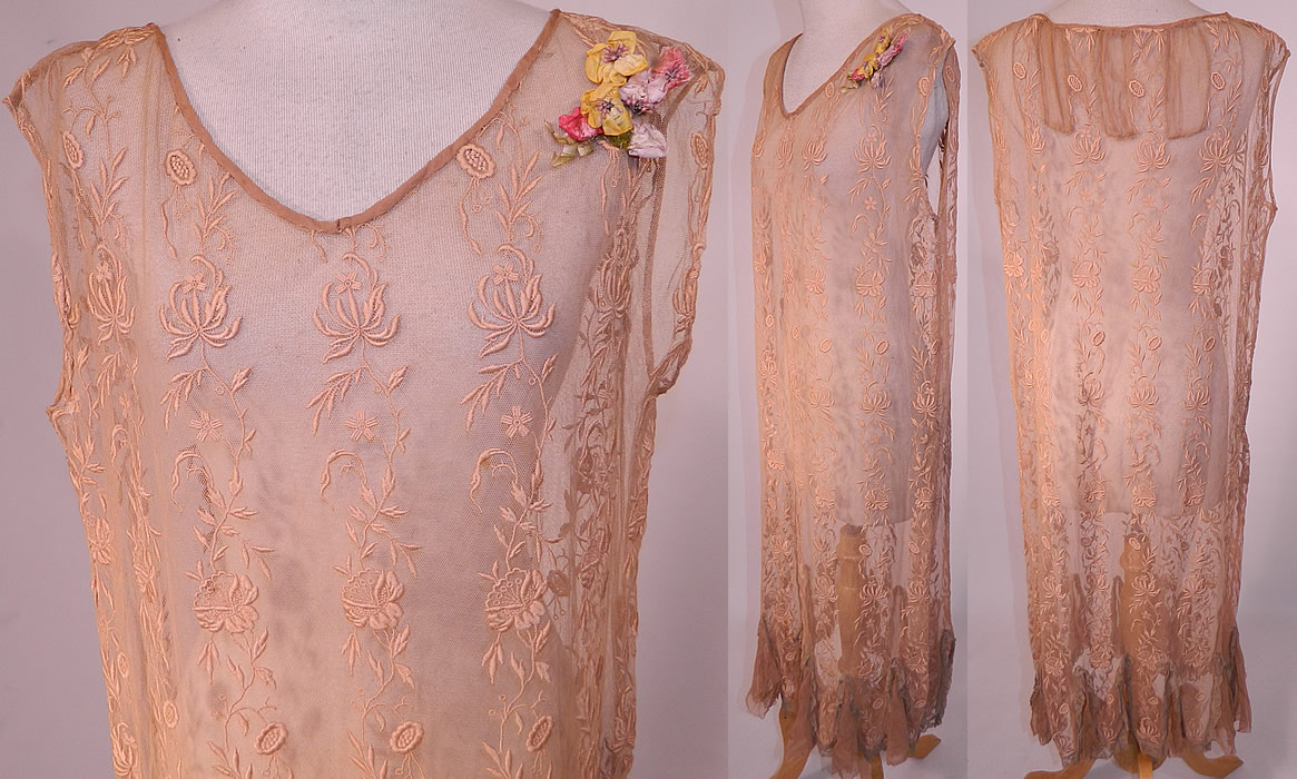 Vintage Ecru Embroidered Net Lace Silk Rosette Chemise Shift Slip Dress.
There is a pastel silk ribbon rosette flower trim on the shoulder. This lovely lace chemise shift style slip dress is loose fitting, sleeveless, with sheer silk chiffon inserts on the back neck, along the bottom lace trim flared handkerchief hemline skirt and is sheer, unlined.