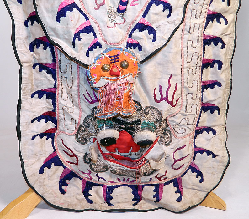 Antique Chinese Dragon Silk Embroidered Peking Opera Warrior Robe
There are raised 3 dimensional dragon faces with large round eyes on the front and sleeves. 