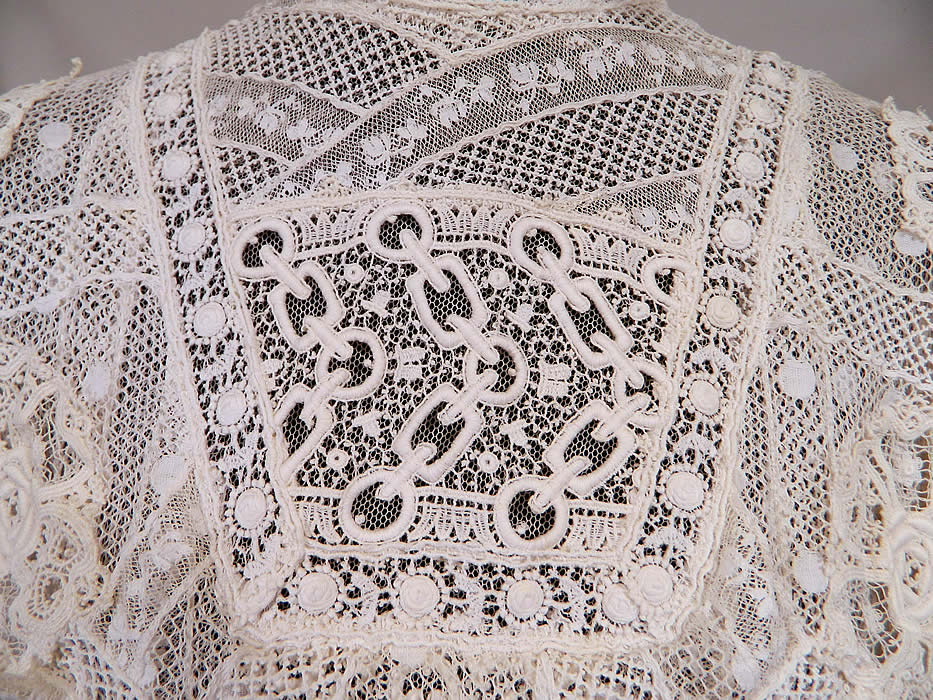 Edwardian Belle Epoque White Mixed Lace Purple Ribbon Skirt Wedding Gown Dress
This lovely lace dress is a long floor length, with a high neck lace collar, layered yoke top, long sleeves, a full bottom skirt, hook closures down the back and is sheer, lined in a net fabric. 