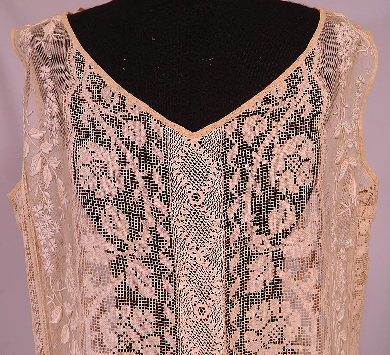 Vintage Embroidered French Knot Net Irish Crochet Filet Lace Chemise Drop Waist Dress
It is made of an off white cream color sheer net fabric with raised padded satin stitch, French knot embroidery work done in a forget-me-not floral vine leaf design, filet lace roses and Irish crochet lace trim down the front & back.