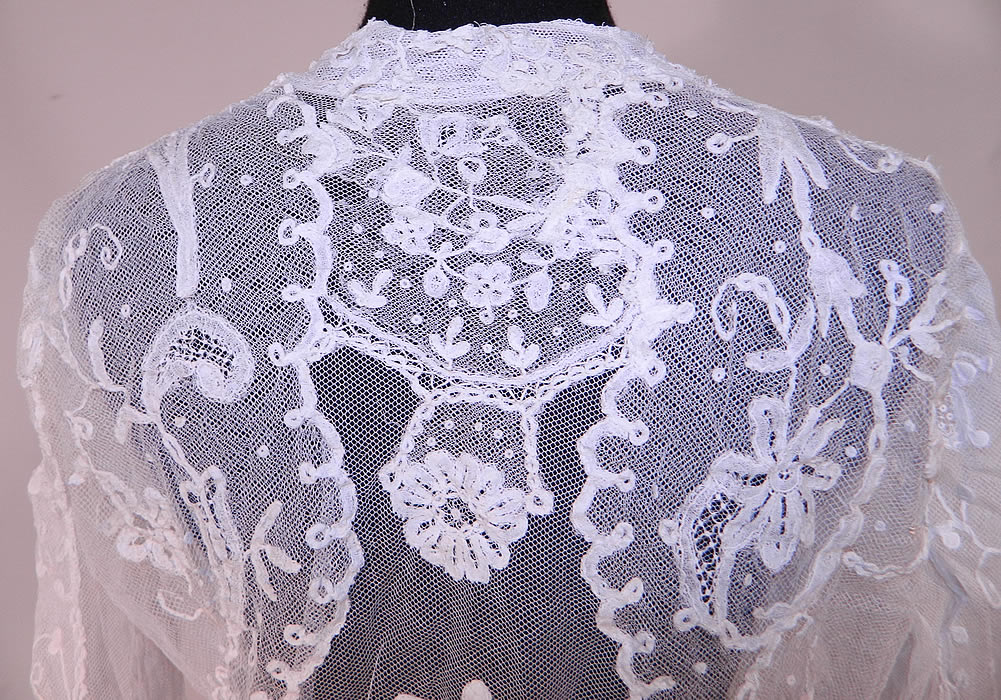 Vintage Edwardian White Net Princess Tape Lace Applique Embroidered Blouse
It is made of a white sheer fine net princess lace fabric, with tambour chain stitch embroidery, tape lace appliqu&eacute; work done in a floral vine leaf, scalloped, polka dot design done primarily on the shirt back and sleeves.