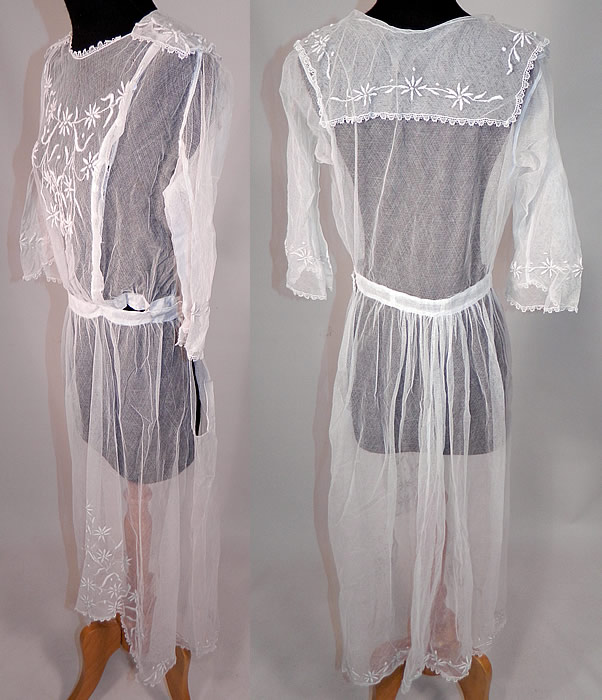 Vintage Edwardian Sheer White Net Floral Embroidered Lace Middy Dress
This lovely lace middy dress is a long mid length with an uneven high low skirt longer in the back, has a middy style sailor collar top, with 3/4 length sleeves, wide flared bell shape cuffs, a fitted waistband, hook closures down the front side and is sheer, completely unlined.