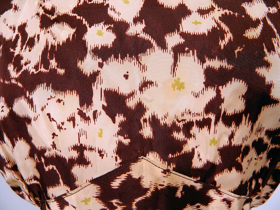 Vintage Ikat Dye Brown Floral Print Silk Moire Taffeta Bias Cut Dress Gown
This gorgeous gown has a fitted bias cut style, with a long floor length skirt, ruffled bottom, brown silk spaghetti straps, fabric covered button closures on the back and is unlined. 