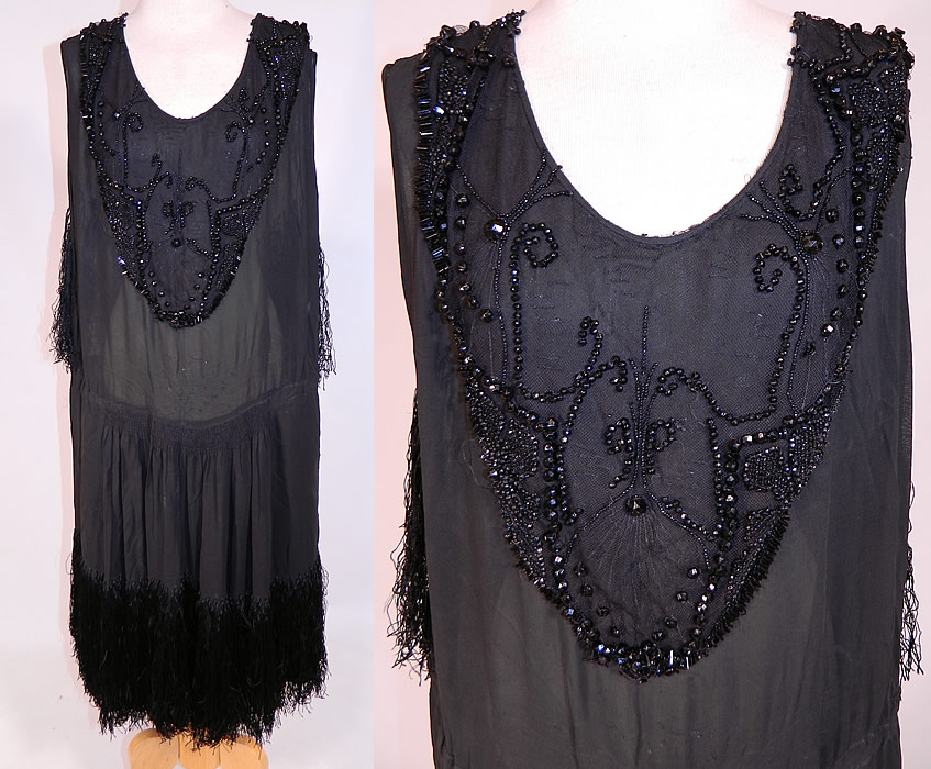 Vintage Art Deco Black Silk Jet Beaded Fringed Flapper Drop Waist Dress
This vintage Art Deco black silk jet beaded fringed flapper drop waist dress dates from the 1920s. It is made of a black sheer silk chiffon fabric, with a jet beaded front bib neckline top backed in net and black silk hand knotted fringe hanging down the back and around the bottom skirt.