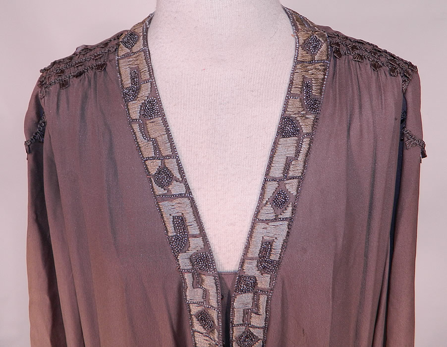 Vintage Art Deco Gray Silk Embroidered Silver Beaded Flapper Drop Waist Dress
This fabulous flapper dress has a loose fitting drop waist style, with ruched smocking along the shoulders, long full sleeves with gauntlet cut work open slit cuffs, overlapping skirt panels, a V front neckline, with hook closures down the front and is lined.