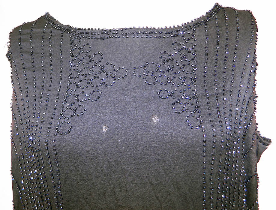 Vintage Art Deco Black Silk Jet Beaded Flapper Drop Waist Side Tie Dress Evening Gown
It is in good condition, with only a few loose missing beads, faint underarm discoloration and two tiny holes on the front top (see close-up). Great for design! This is truly a wonderful piece of Art Deco wearable beaded textile art!