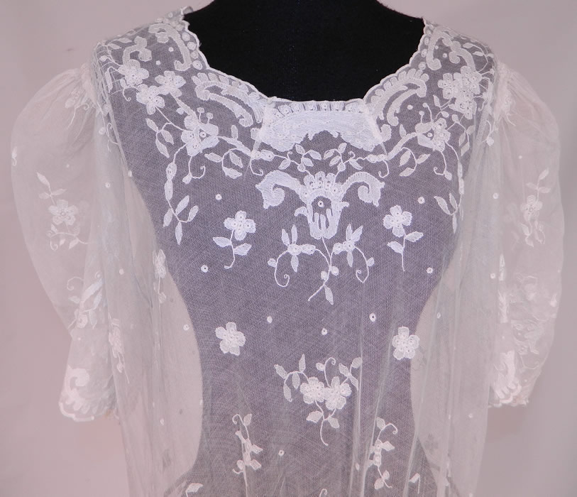 Vintage White Tambour Embroidery Lace Sheer Silk Tulle Net Drop Waist Dress
This lovely lace drop waist dress is loose fitting, with a scalloped neckline, gathered shoulders with woven crinoline padding, short puffy sleeves, a decorative embroidered waist, side snap closures and is sheer because it is unlined.