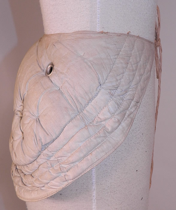 Victorian Antique Grommet Bustle Quilted Cotton Pad Pillow Crescent Crinolette
There is a linen cloth strap waistband belt with adjustable tie front closure. This unique undergarment would have been worn under a bustle skirt dress to expand the fullness or support the back drape of the fanned train skirt.