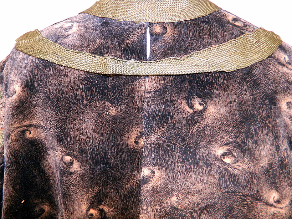 Edwardian Black Velvet Gold Print Peacock Hurricane Eye Cyclone Coat
The coat measures 33 inches long, with 60 inch hips, a 60 inch waist, 50 inch bust and 21 inch long sleeves. It is in good as-is condition, with a small fray on the front top insert, back neck seam and several brown stains, with frayed holes on the cream silk sleeve lining (see close-ups). This is truly a wonderful piece of wearable textile art! 