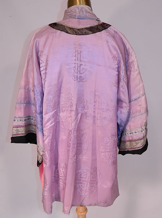 Antique Chinese Character Embroidered Purple Lilac Silk Damask Brocade Robe
This lovely lilac Manchu womens robe is a short mid length, has a mandarin collar, decorative black silk appliqué front with pink knotted trim edging, replaced newer buttons with loop toggle closures, long full sleeves and has been relined in a pink cotton fabric. 