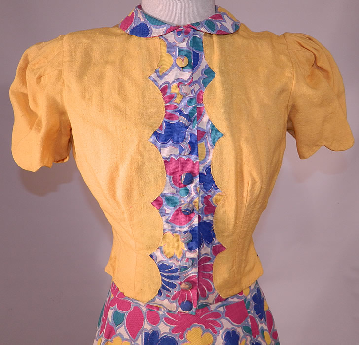 Vintage Colorful Cotton Pique Floral Print Halter Top Dress Gown & Jacket
This stunning summer sun dress has a halter top style with neck strap, sweetheart neckline, a long floor length full skirt, fitted waist and back zipper closure. The dress measures 65 inches long, with a 24 inch waist and 34 inch bust. There is a matching fabric short cropped bolero style jacket, with gathered shoulders, short puffy sleeves, peter pan collar, decorative button trim with snap closures hidden underneath down the front. 