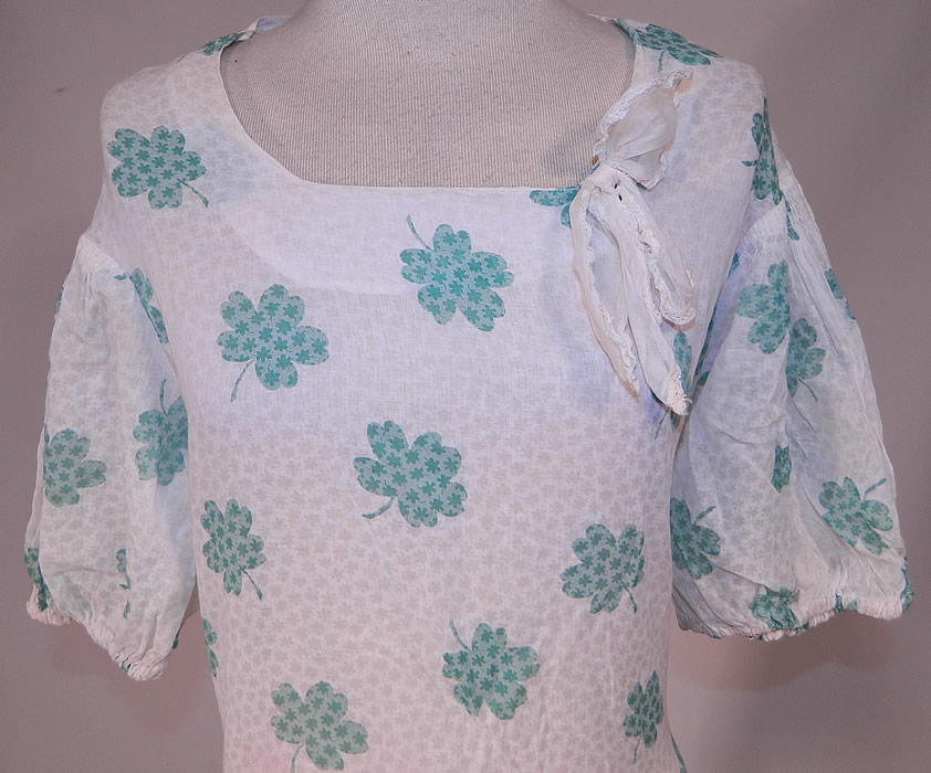 Vintage Green Shamrock Clover Print White Cotton Bias Cut St. Patricks Day Dress
This delightful St. Patrick's day dress has a fitted bias cut, lace trimmed bow tie on the neckline, gathered smocking along the shoulders, short puffy sleeves and is sheer, unlined. 